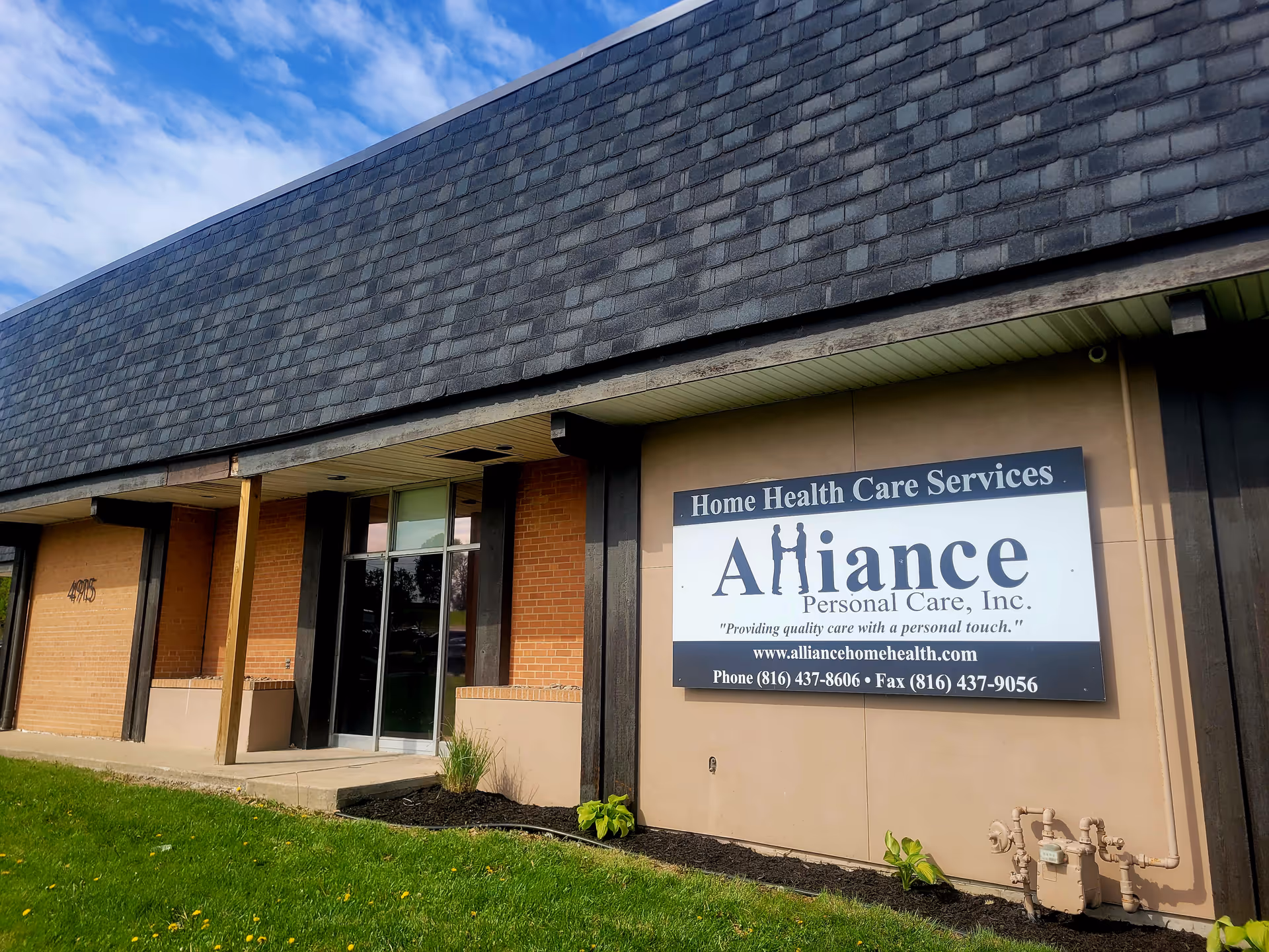 Exterior view of Alliance Personal Care, Inc building with entrance and sign.