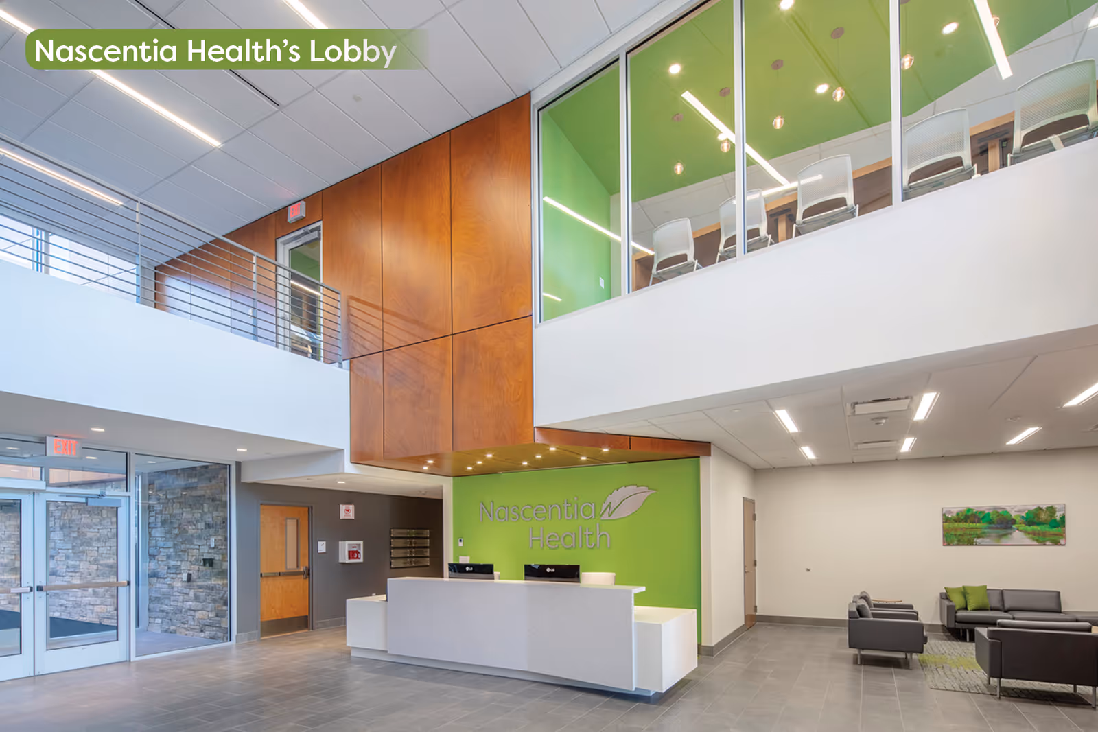 Modern hospital lobby with reception desk, green Nascentia Health wall, and seating area.
