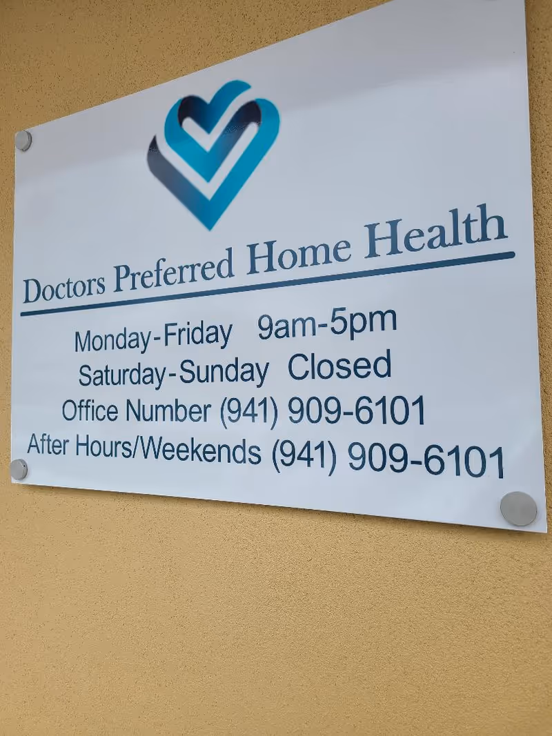 White sign on tan wall advertises Doctors Preferred Home Health with hours and phone