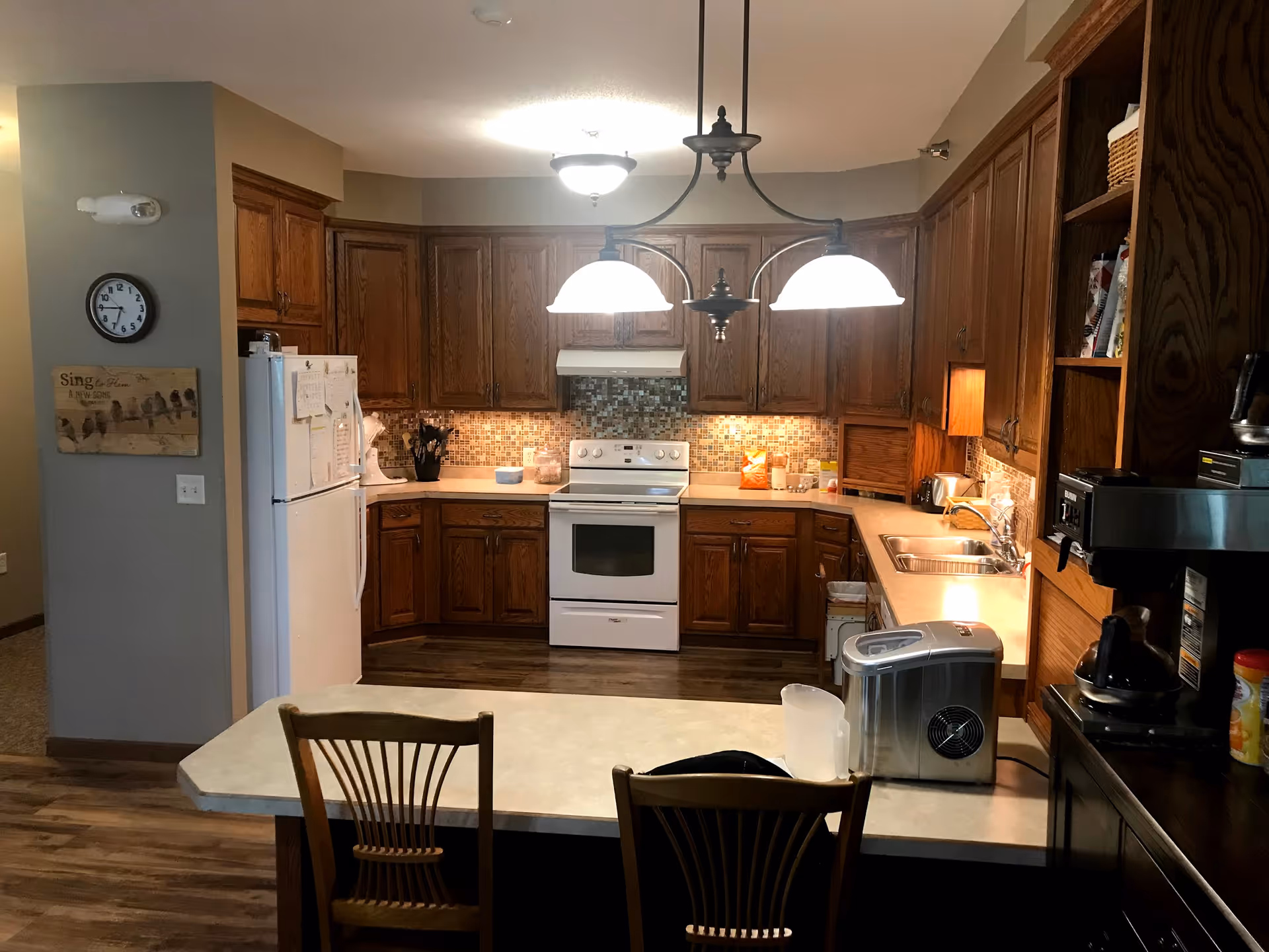 A spacious kitchen with wooden cabinets, white appliances, and an island.
