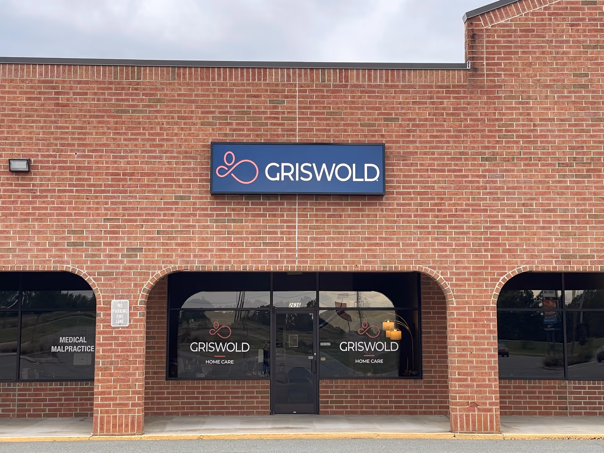 Brick building front displaying Griswold Home Care sign and glass entry doors.