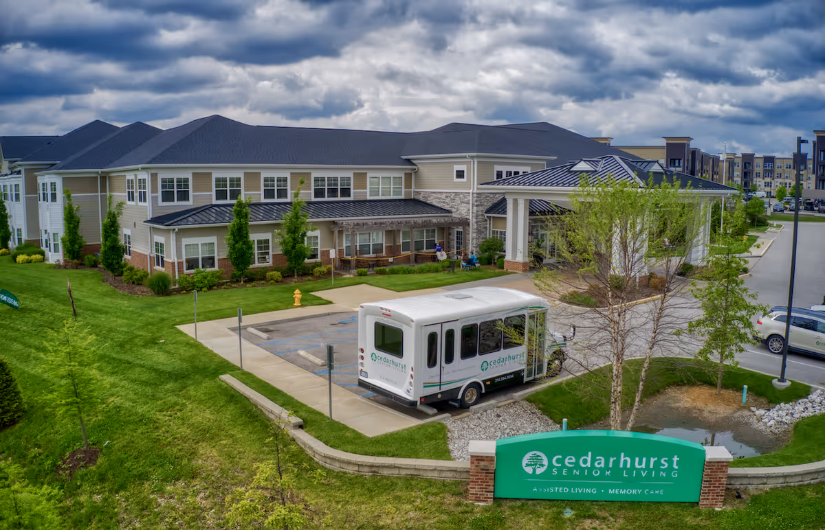 Exterior view of Cedarhurst Senior Living building with a shuttle bus in front.