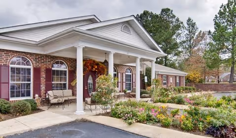 Exterior view of Southern Oaks senior living facility with a covered entrance and landscaped garden.