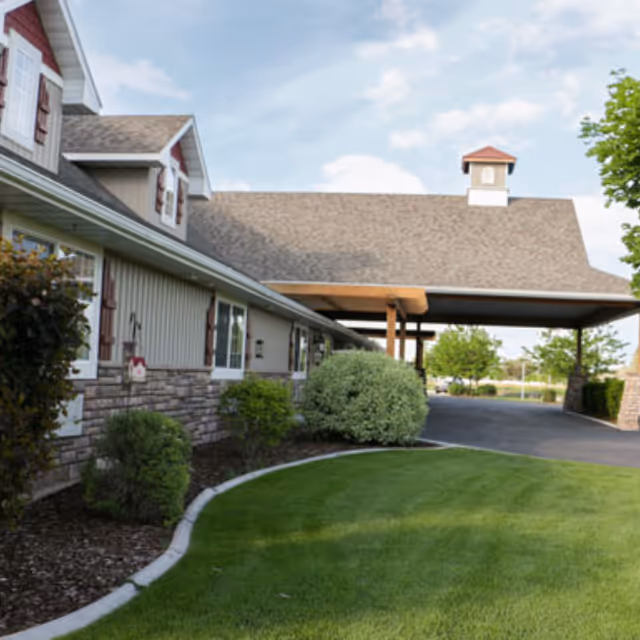 Exterior view of The Gables Memory Care of Shelley with manicured lawn and driveway.