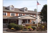 Front view of Apple Rehab Laurel Woods with entrance, flagpole, and manicured landscaping