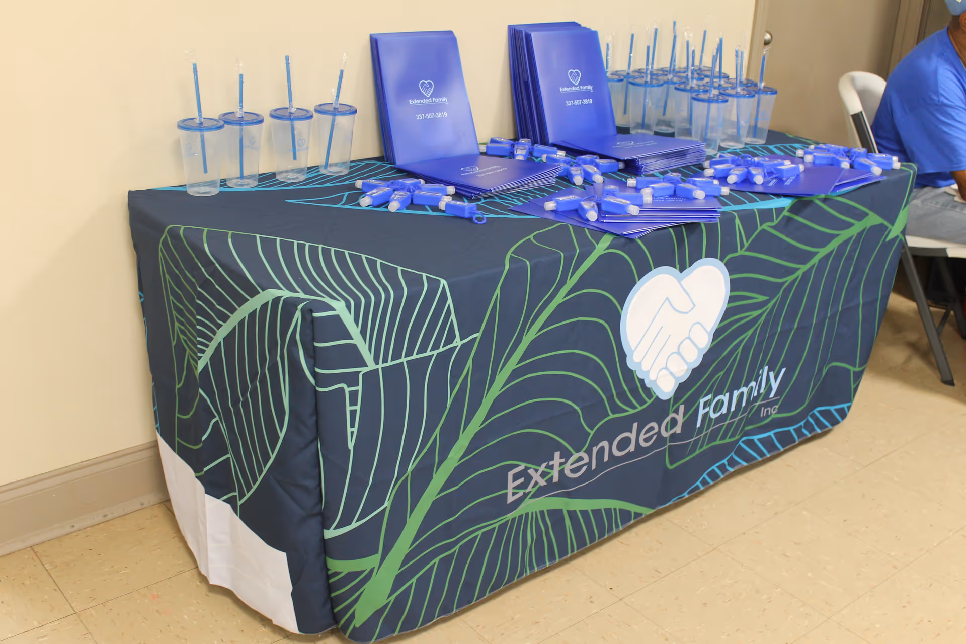 Promotional table with Extended Family Inc. branding and informational materials.