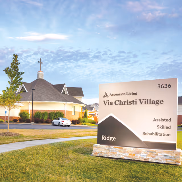 Exterior view of Via Christi Village with a prominent front sign.