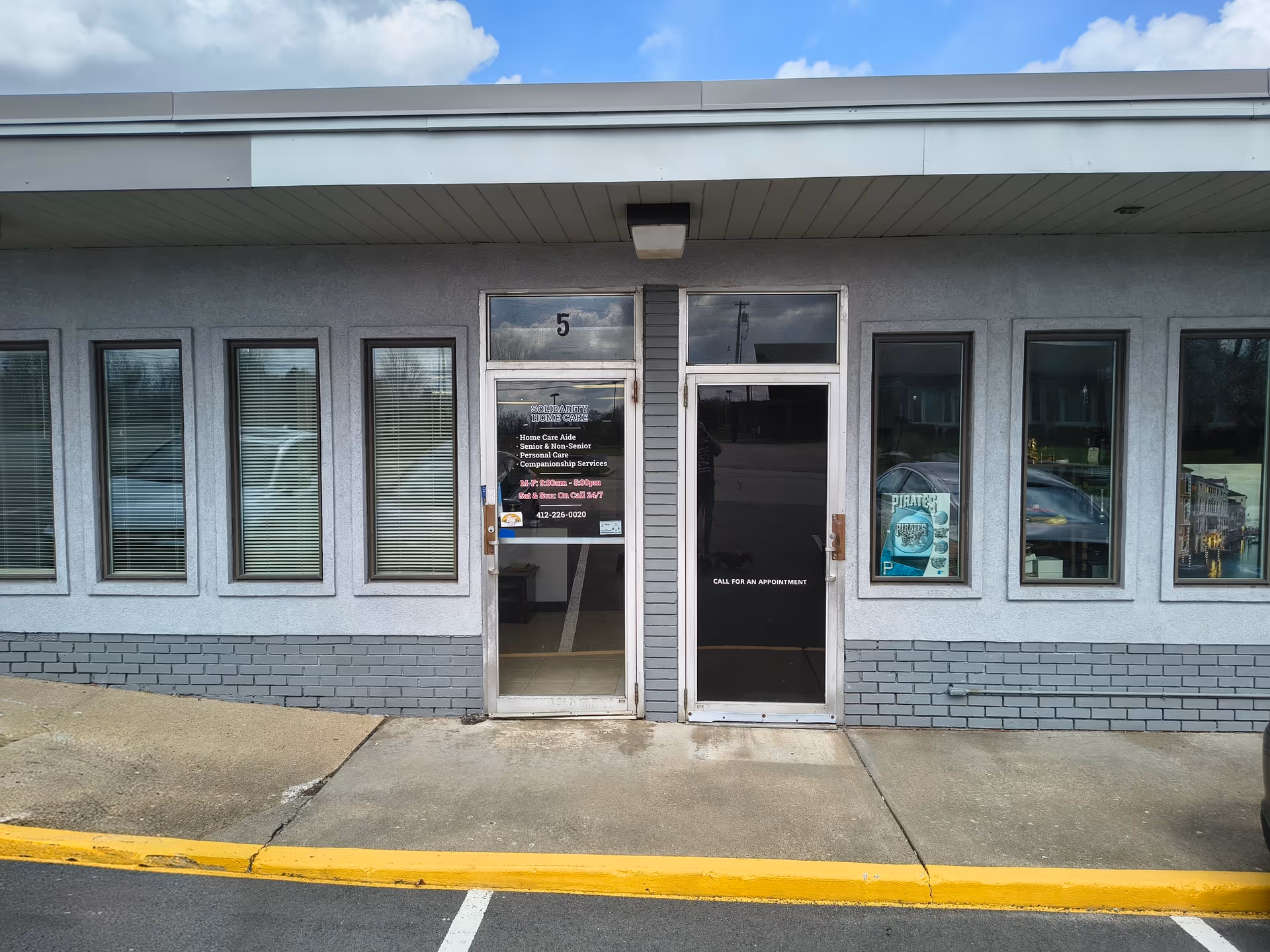 Exterior of a single-story building with two glass doors and multiple windows.