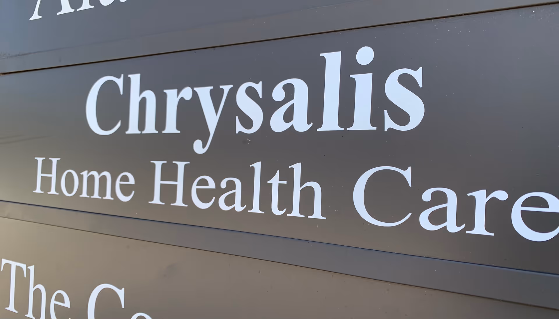 Close-up of Chrysalis Home Health Care sign on a building exterior.