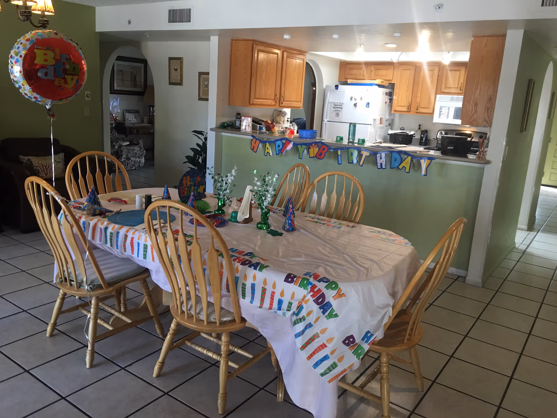 Senior living dining area decorated with birthday party supplies around a long table.