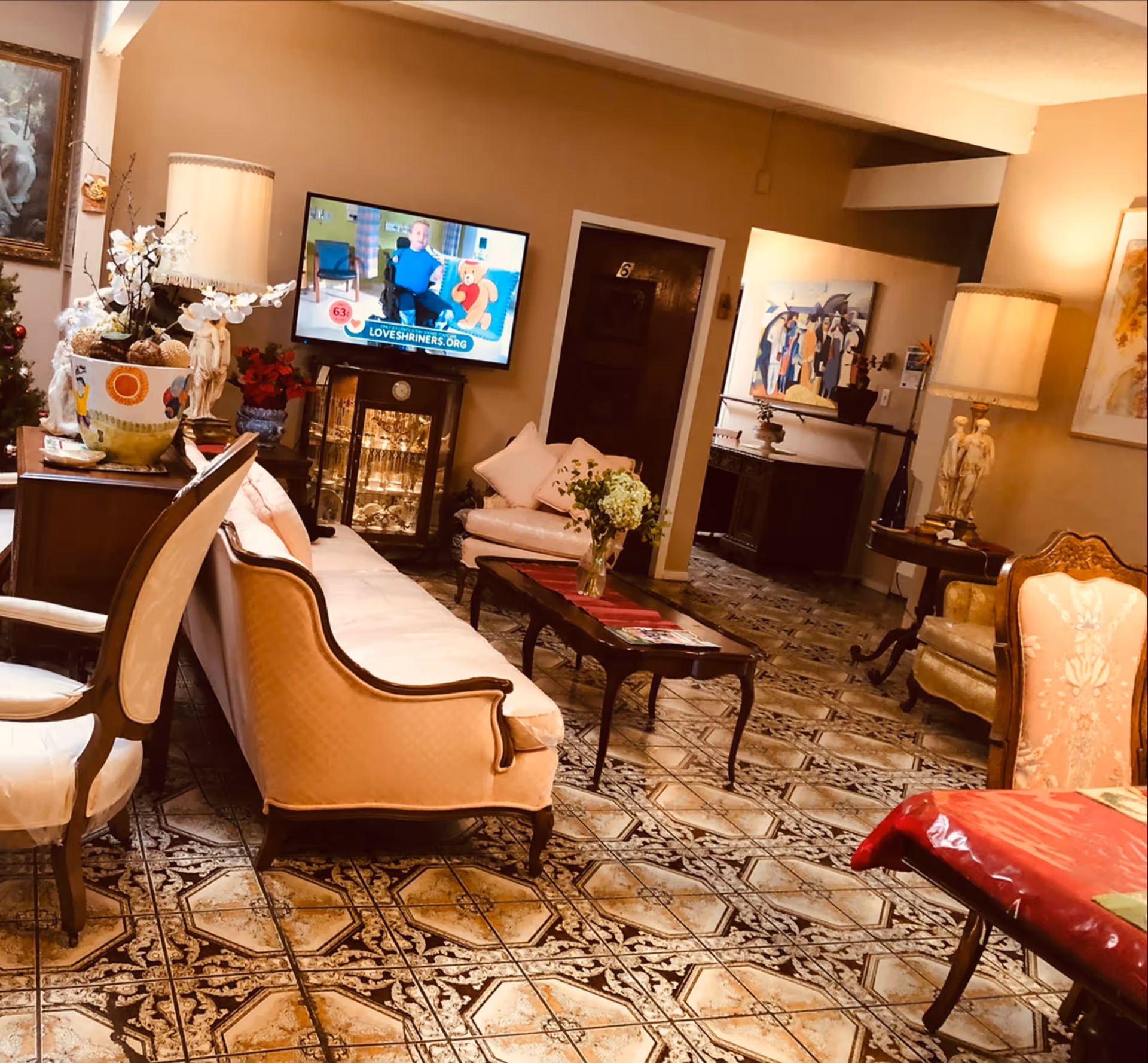 Vanessa Care Home II living room with vintage furniture, TV, lamps, and a tiled floor.