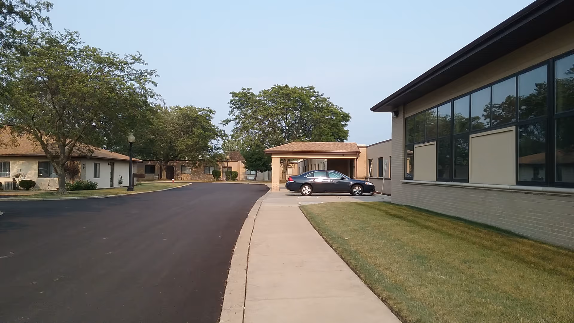 Exterior view of North Park Care Center with parking lot and green lawn.