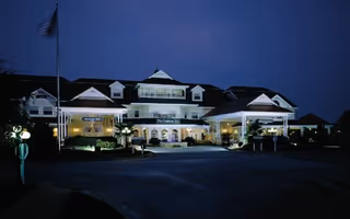 Nighttime exterior view of The Huntingdon senior living facility with illuminated entrance and driveway.