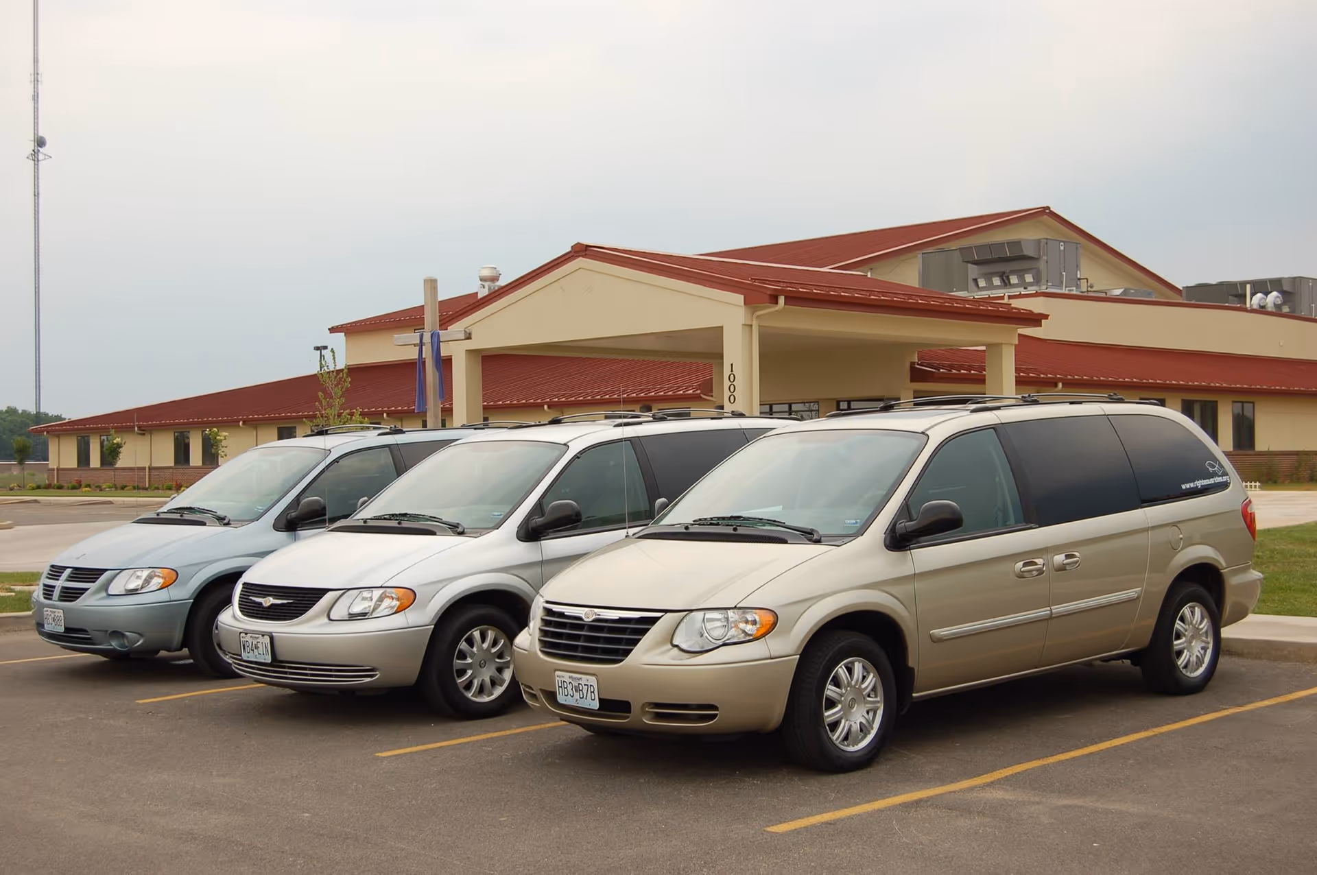 Front view of Coleman Care Givers LLC facility with several vans parked outside.