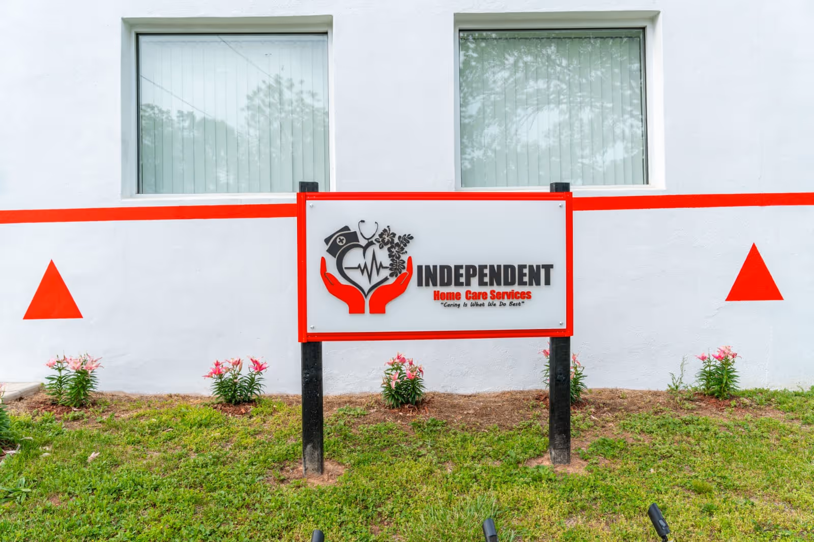 Exterior view of a white building with a red-trimmed sign for Independent Home Care Services
