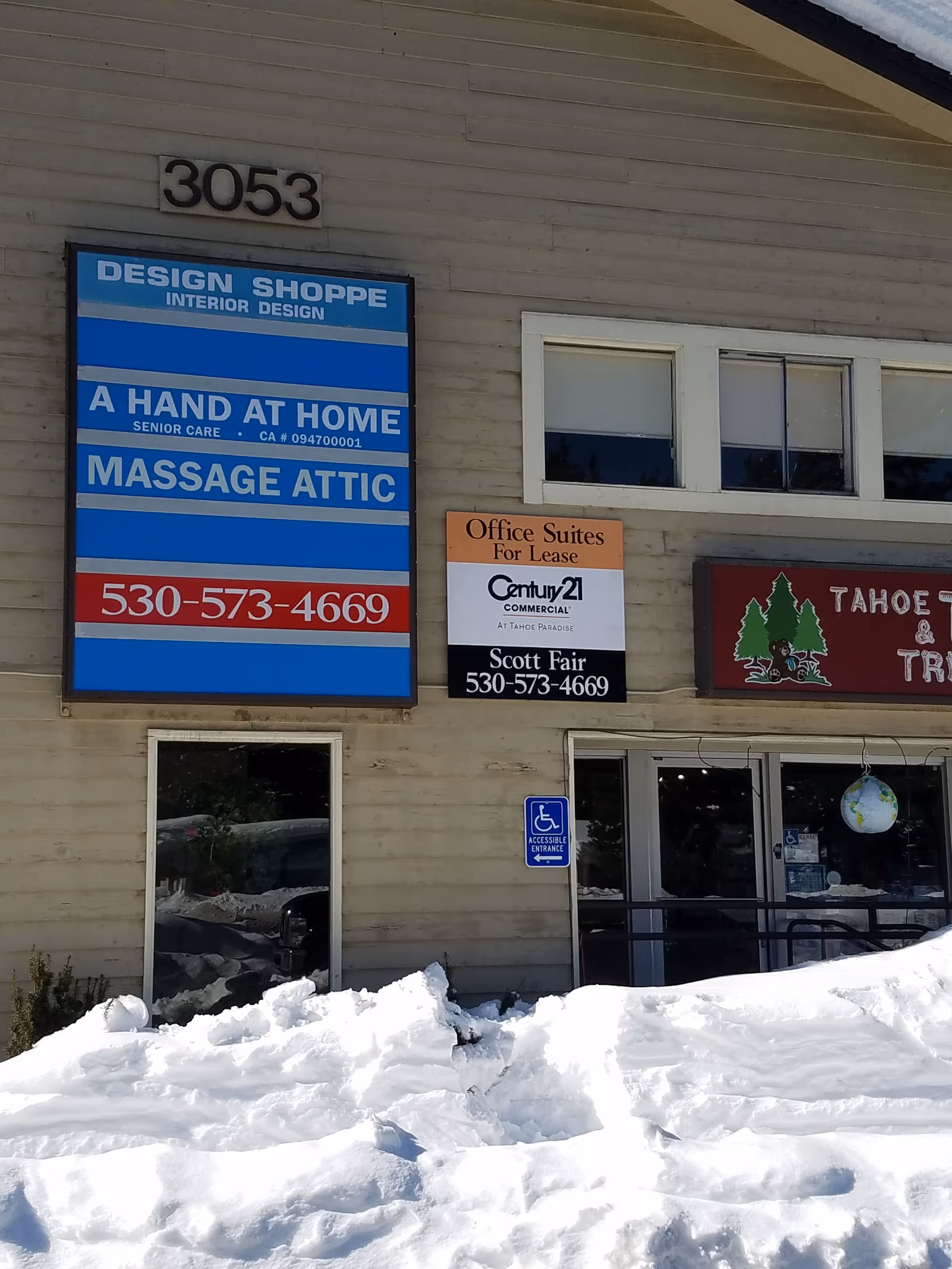 Front of a beige building with multiple business signs, including A Hand At Home Senior Care.