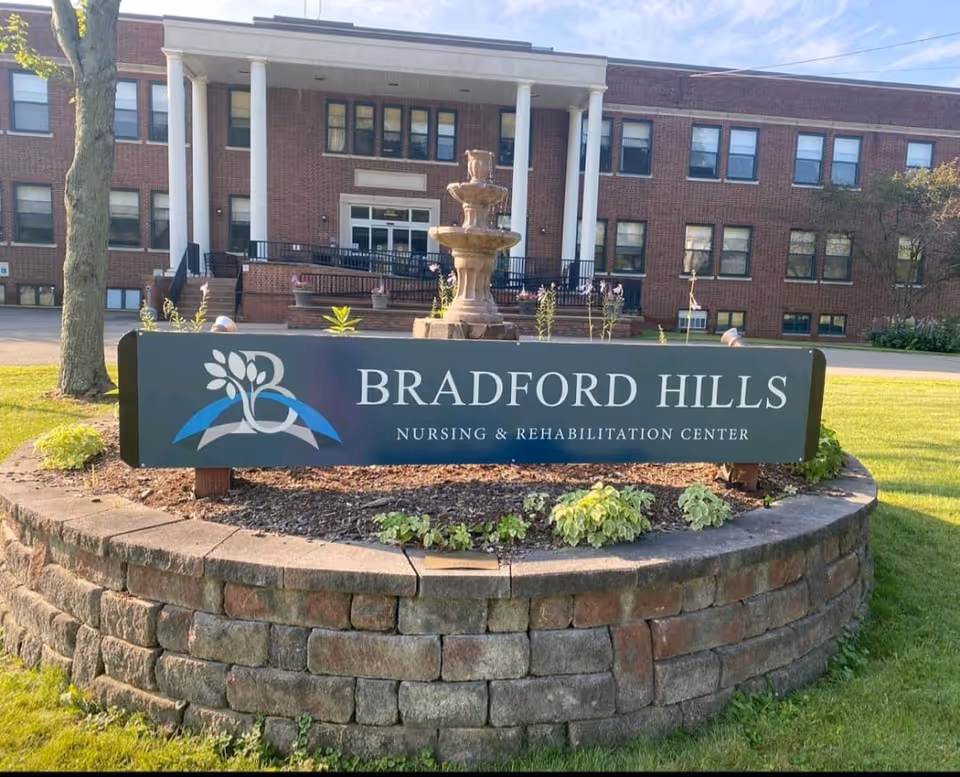 Sign for Bradford Hills Nursing & Rehabilitation Center in front of a brick building with a fountain.