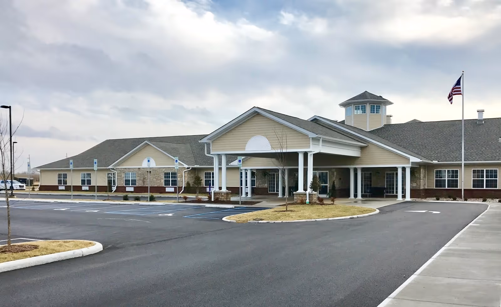 Exterior view of Valley View Health Campus building with a covered entrance, multiple windows, an American flag on a flagpole, and a parking lot with handicap parking spaces in front.