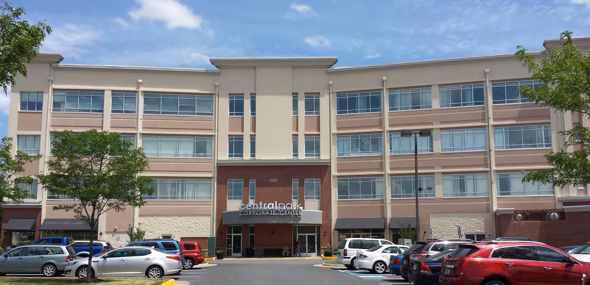 Exterior view of a multi-story senior living facility with a front parking lot.