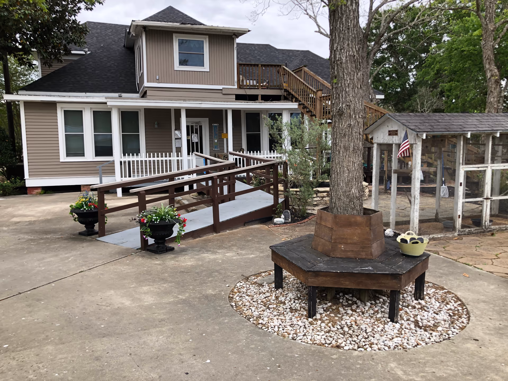 Exterior view of a senior living facility with ramp and outdoor seating.
