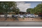 Exterior view of Knopp Retirement Center with several parked cars in front.