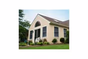 Meadowood Senior Living building front with an arched window and manicured lawn.