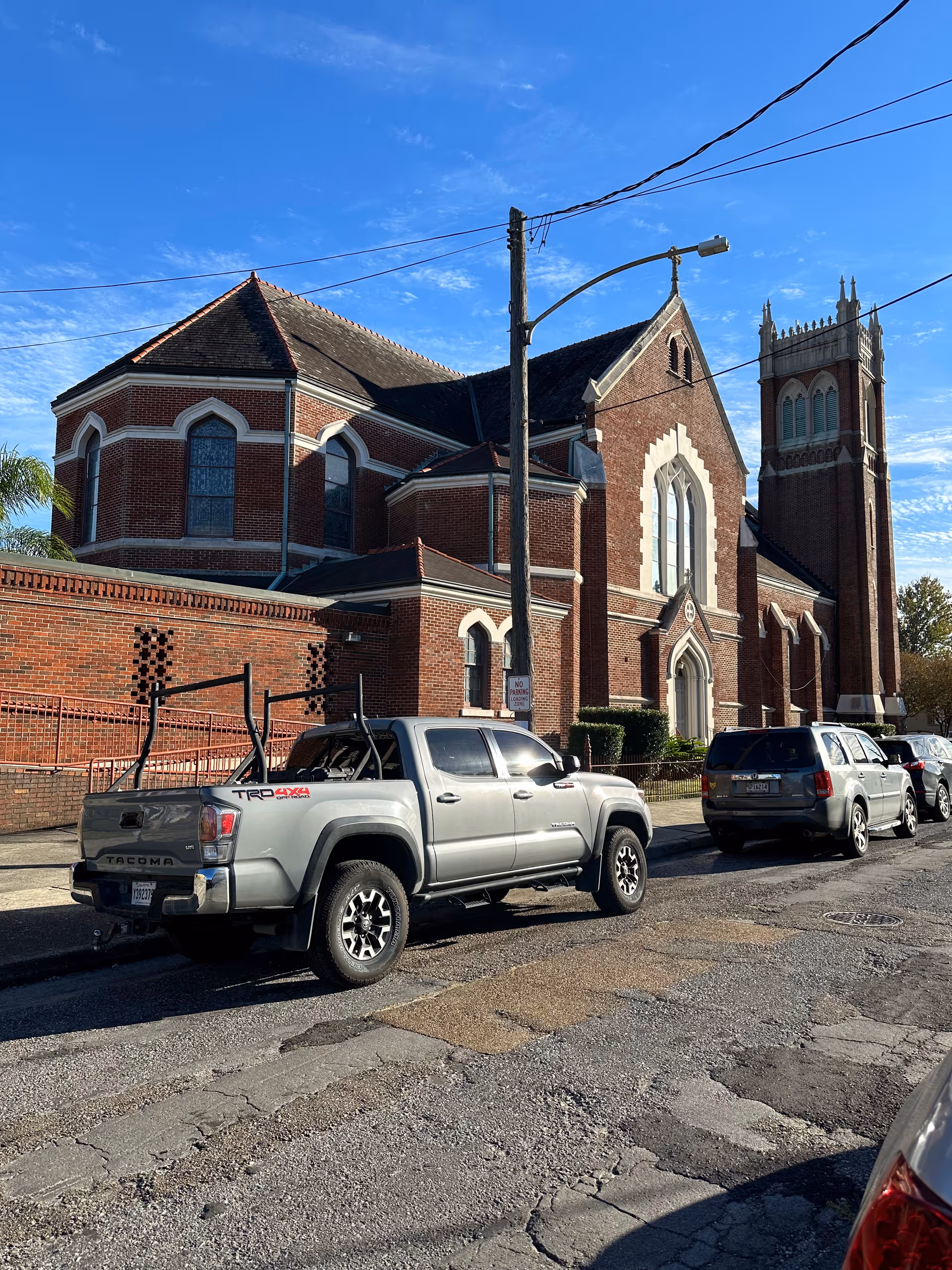 Exterior view of PACE Greater New Orleans facility: brick building with arched windows and parked cars.