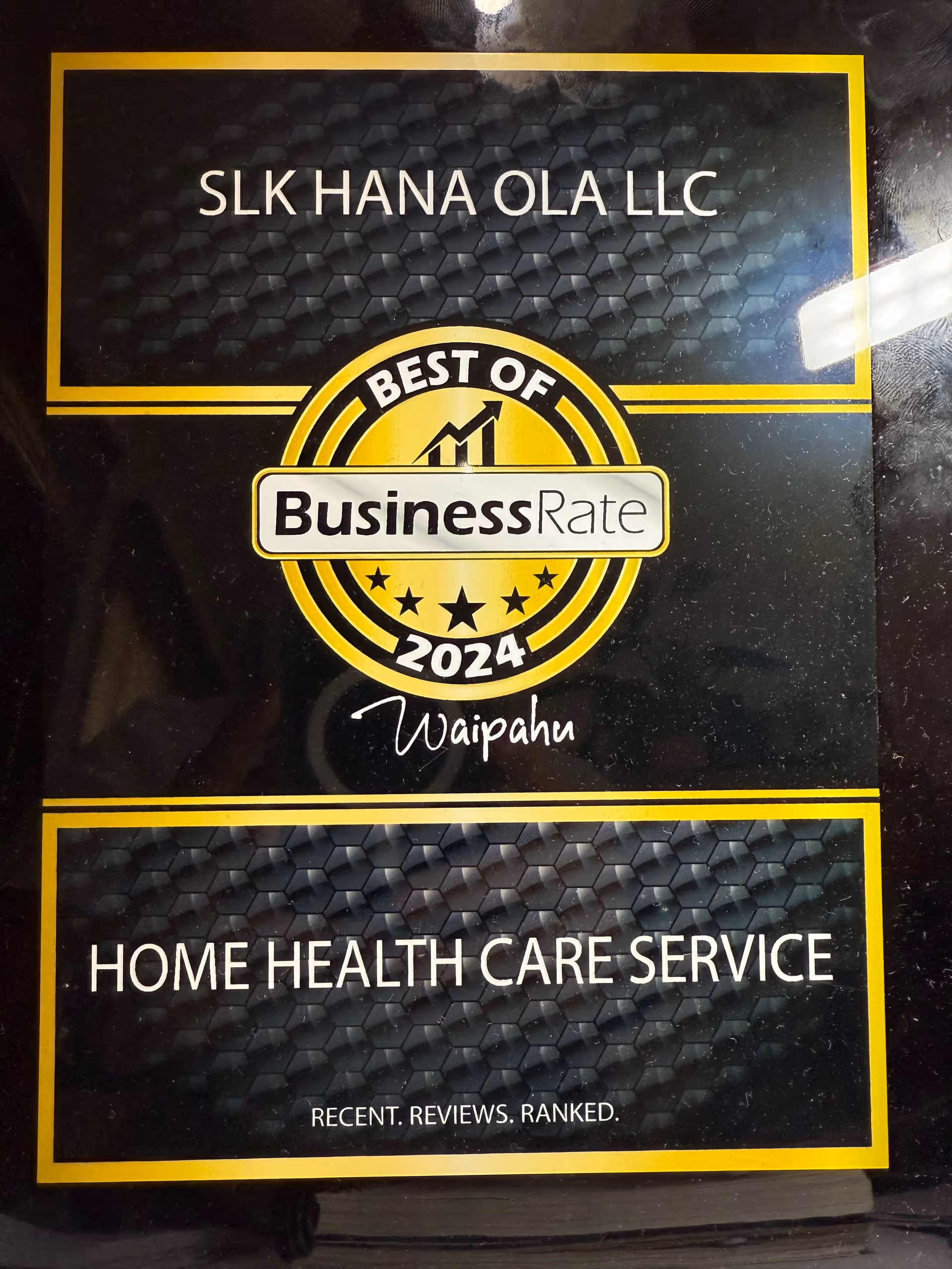 Sign displaying SLK HANA OLA LLC with Best of BusinessRate 2024 and Home Health Care Service.