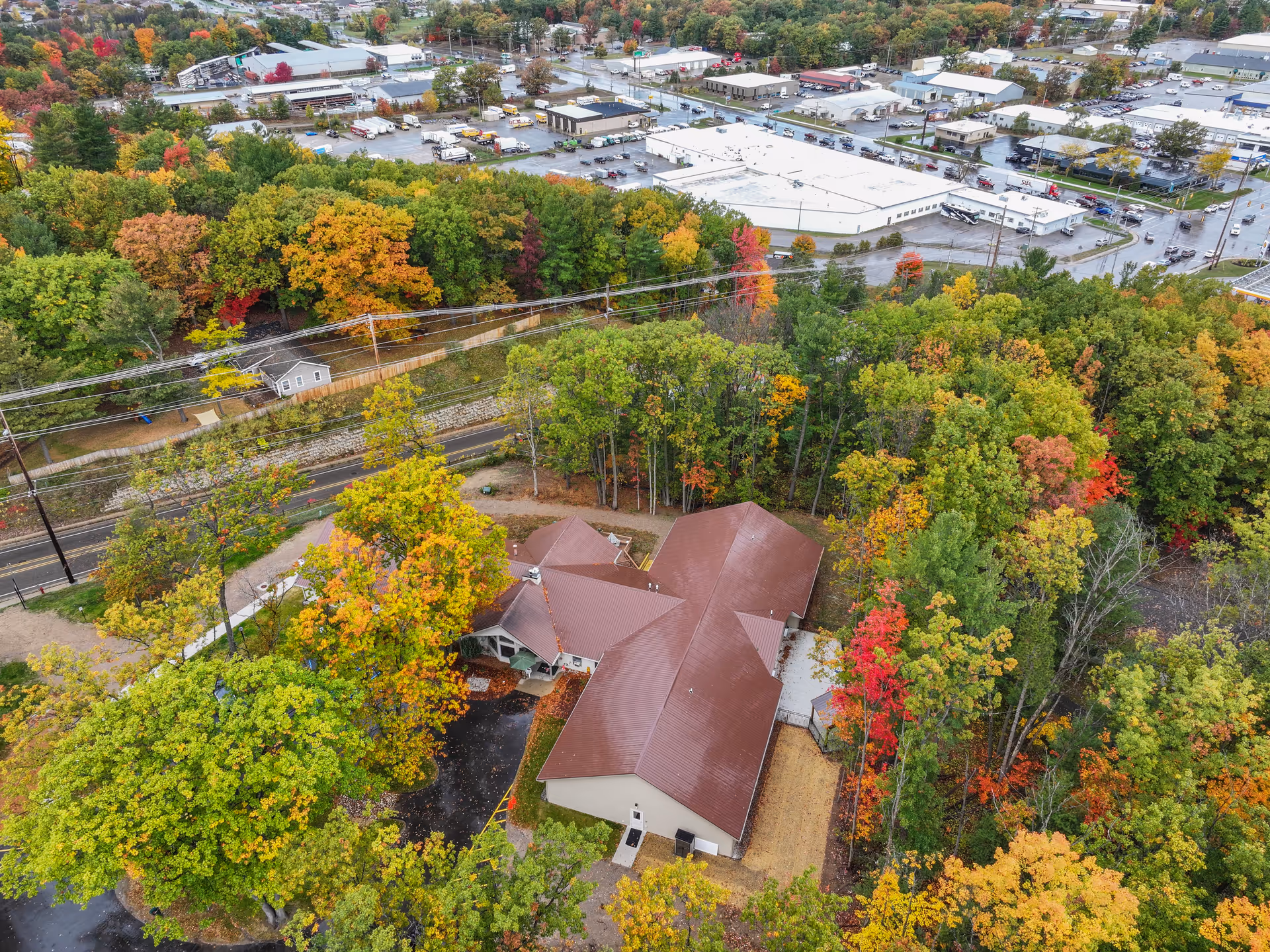 Aerial view of Rosegate Residential Care building surrounded by autumn trees.