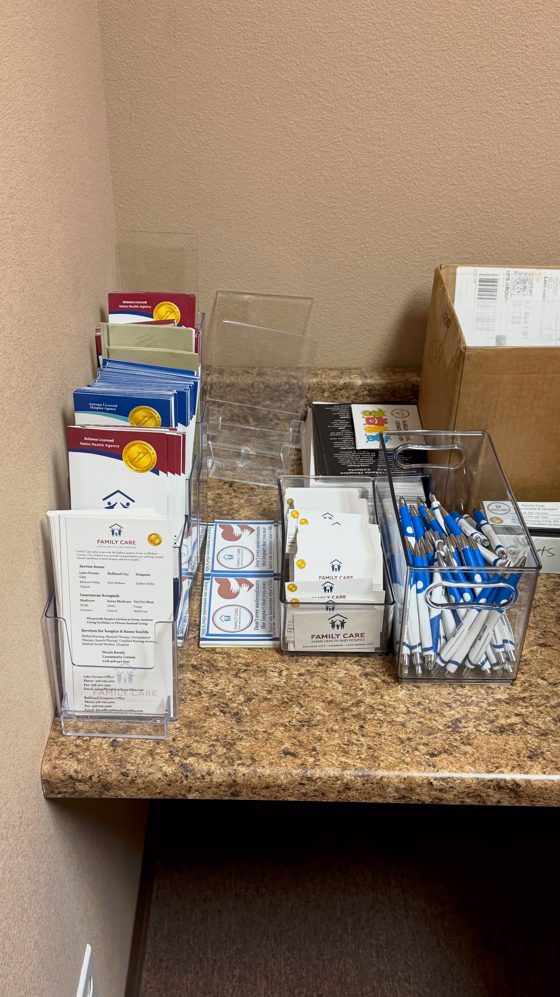 Beige counter displaying brochure racks, business cards, and a pen holder with Family Care materials.