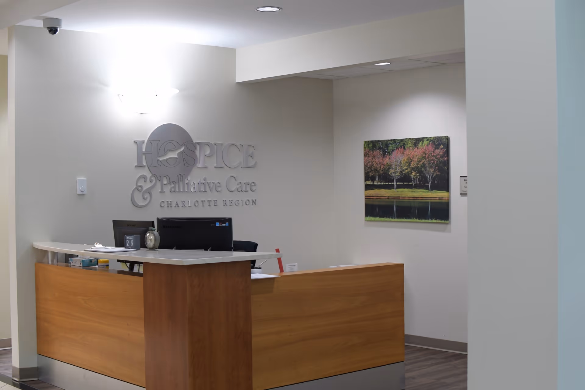Reception desk in a medical facility lobby with computer and wall sign.