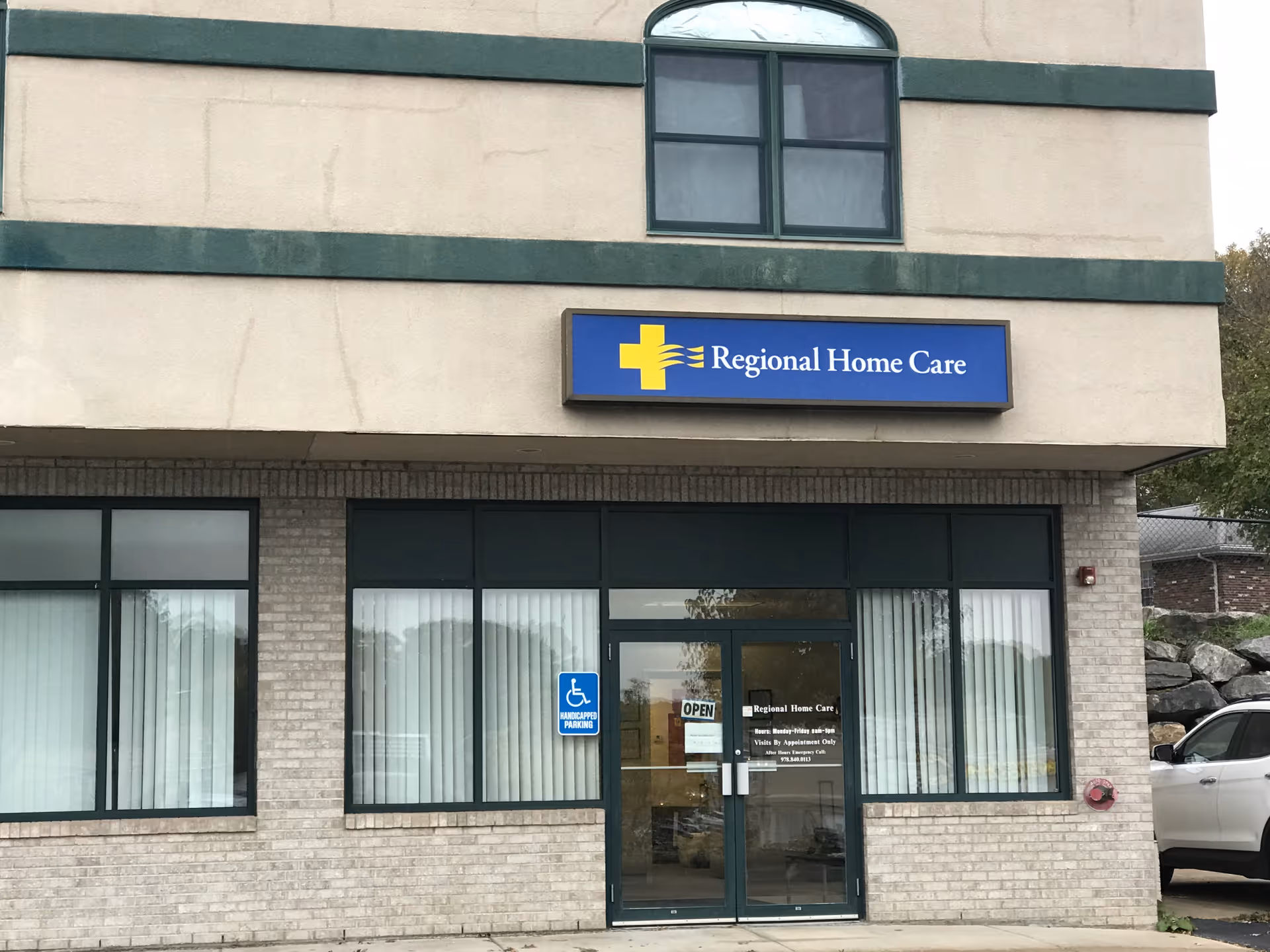 Exterior of Regional Home Care building featuring blue sign, glass doors, and handicap parking.
