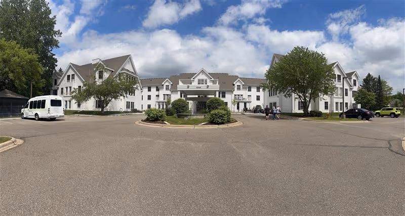 Exterior view of Ecumen Lakeview Commons with a circular driveway and parked vehicles.