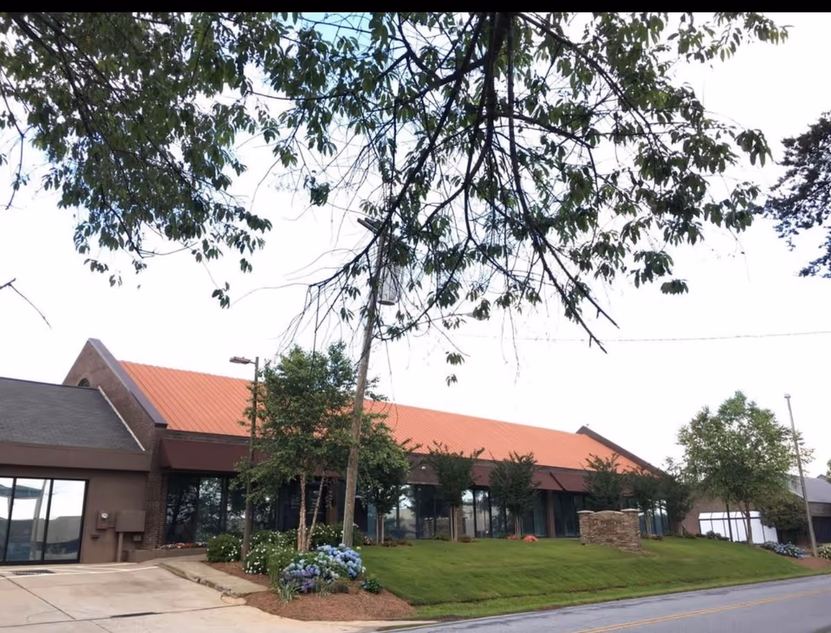Exterior view of Humble Hands Healthcare building with orange roof and landscaping.