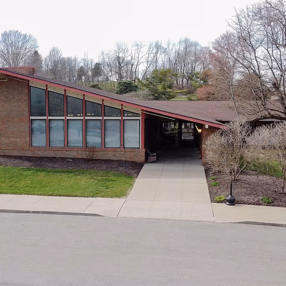 Exterior view of a single-story nursing center entrance with large front windows.