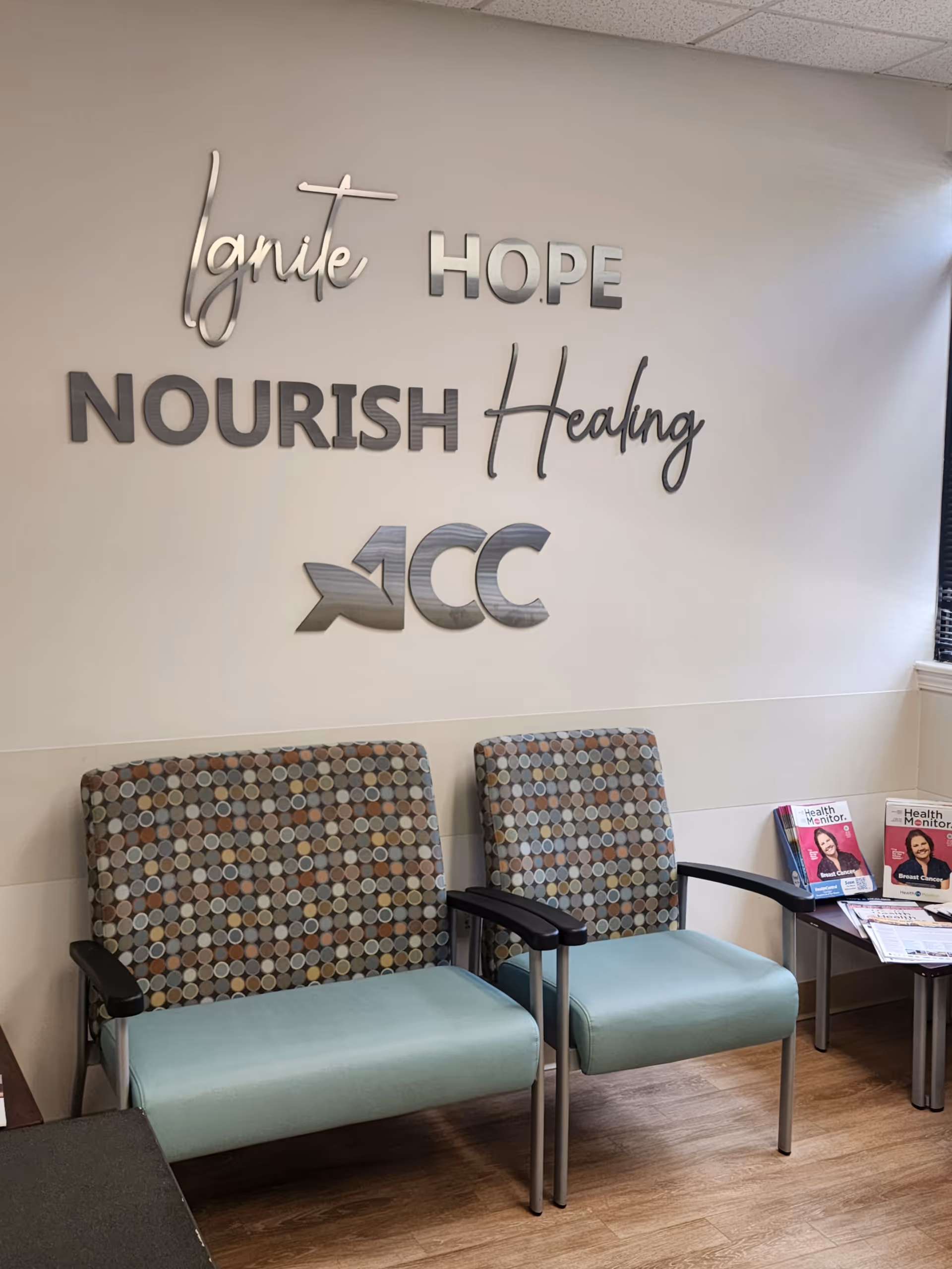 Waiting area with two patterned chairs beside a wall sign reading Nourish Healing.