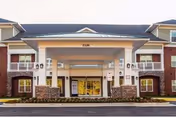 Front entrance of a senior living facility with brick exterior and covered drop-off.