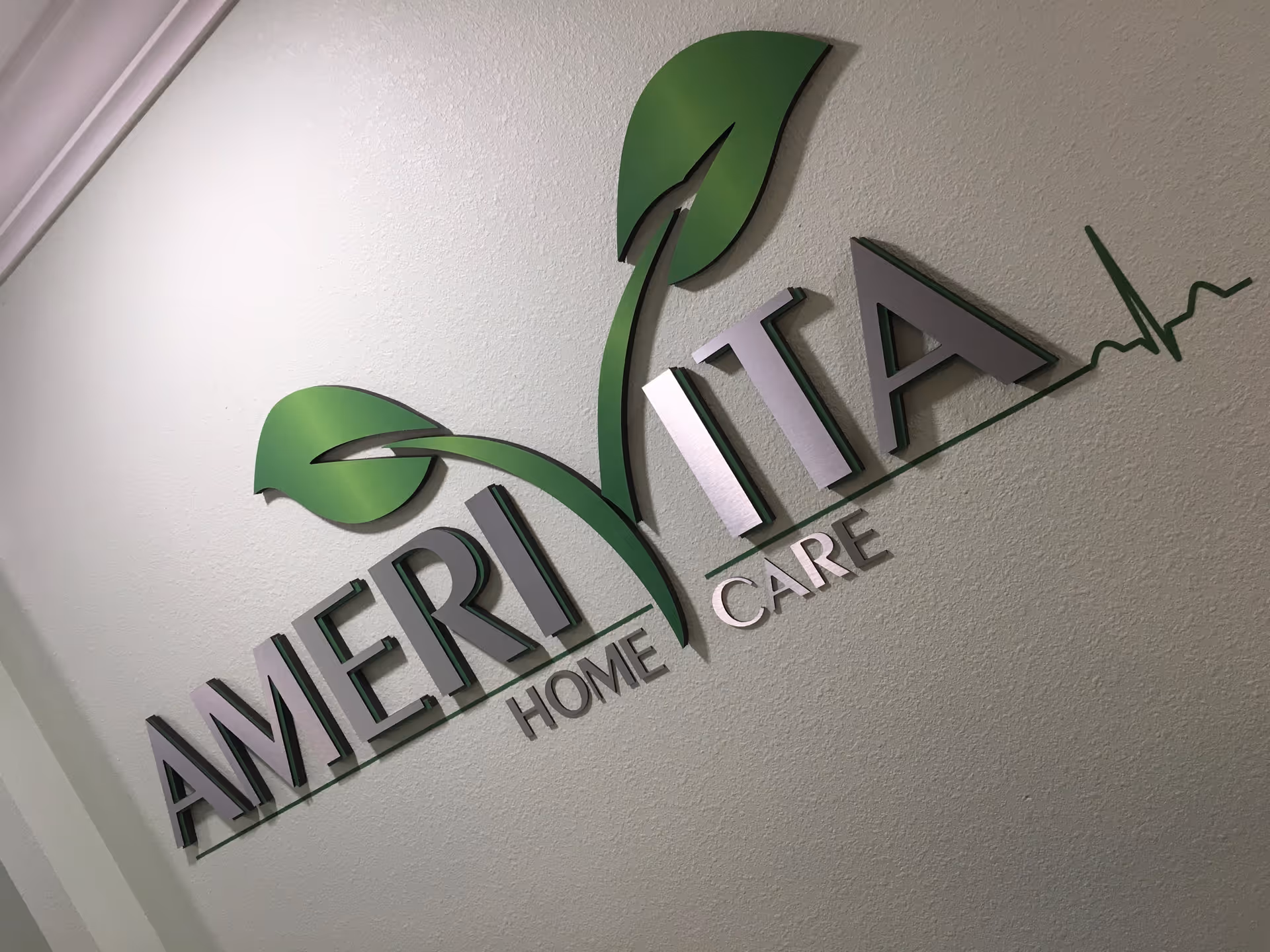 Interior wall sign displaying Amerivita Home Care logo with a green leaf design.