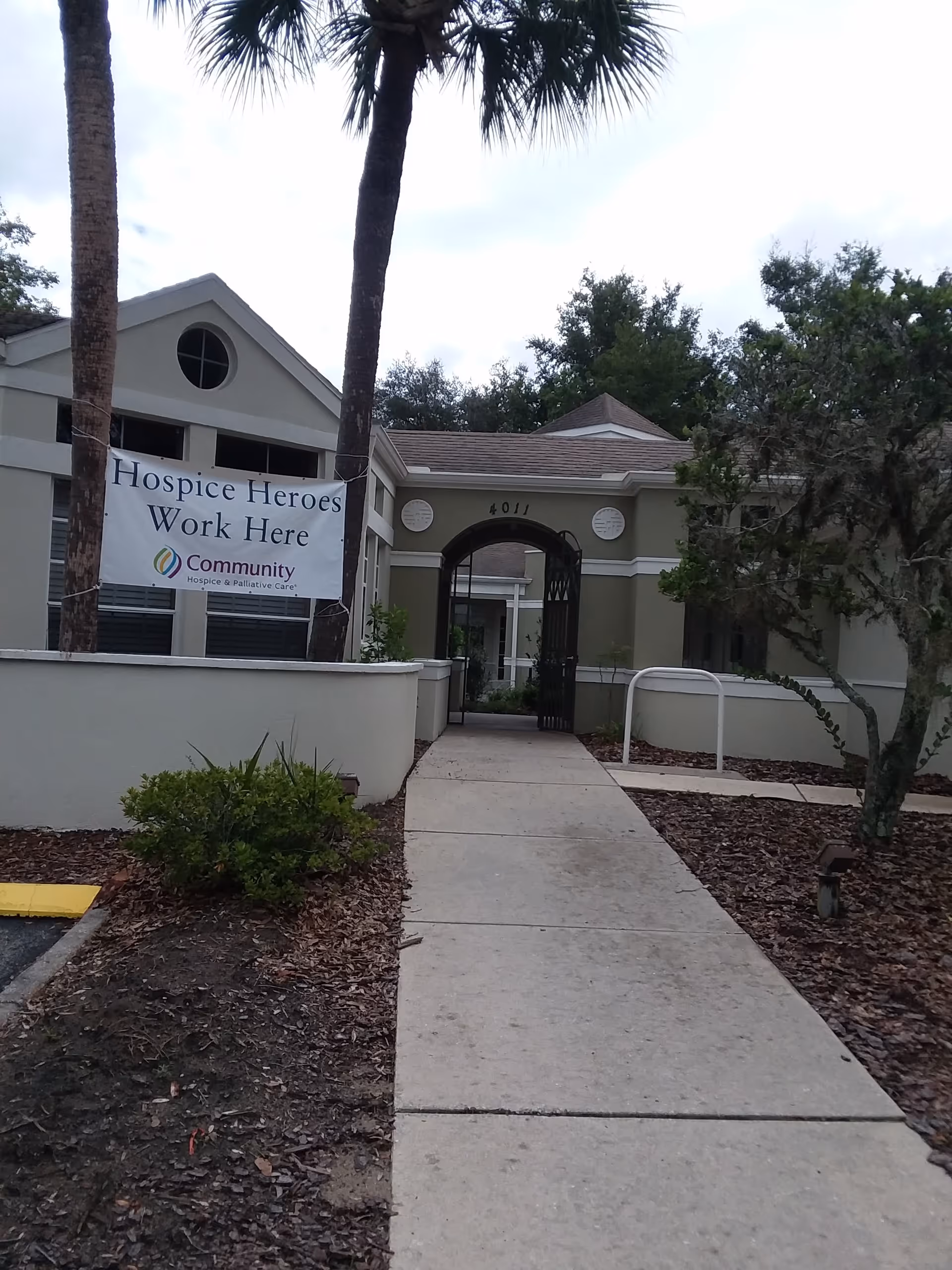 Facility entrance with banner reading Hospice Heroes Work Here for Community Hospice & Palliative Care.