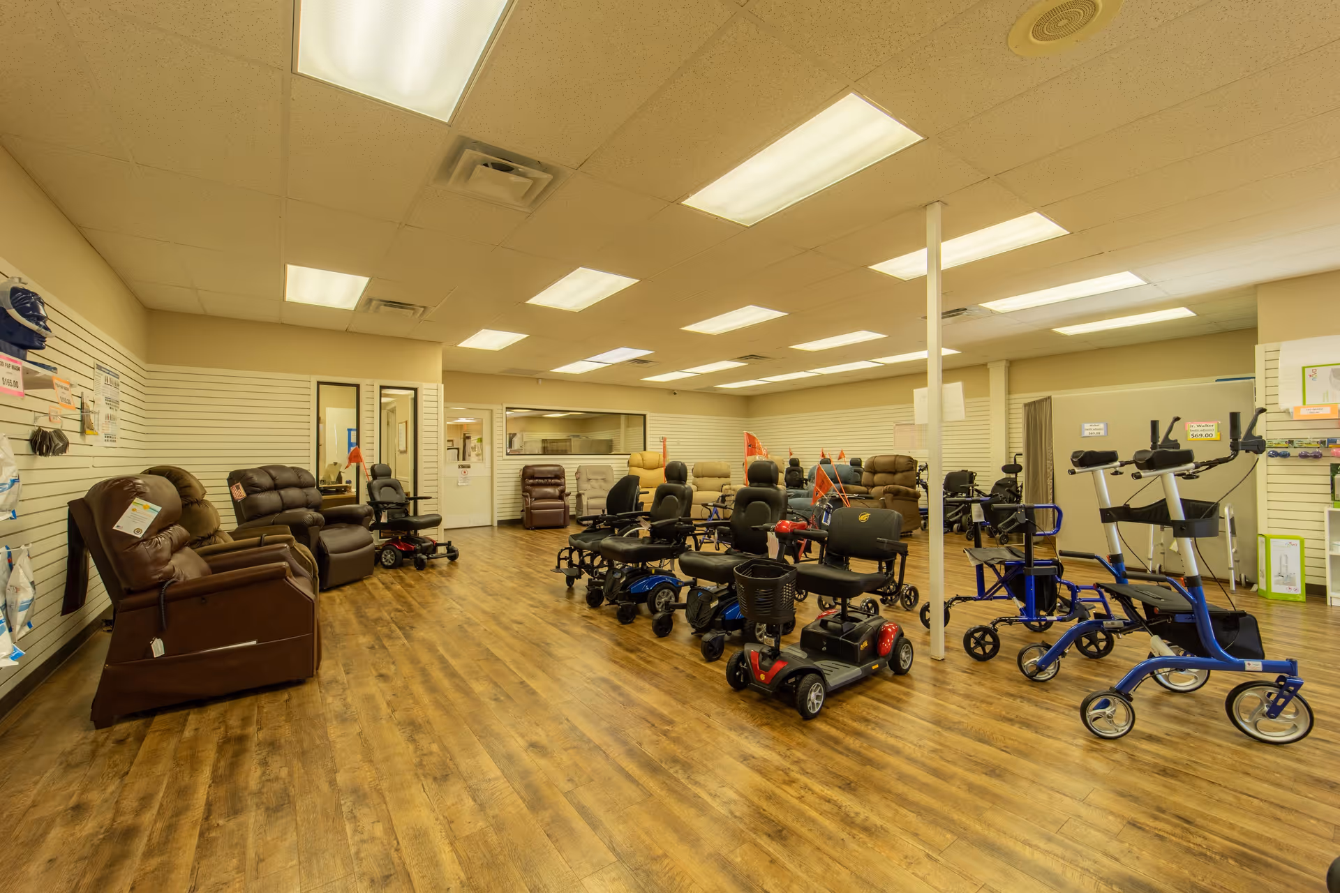 Interior showroom with mobility scooters, chairs, and medical equipment arranged on wood floor