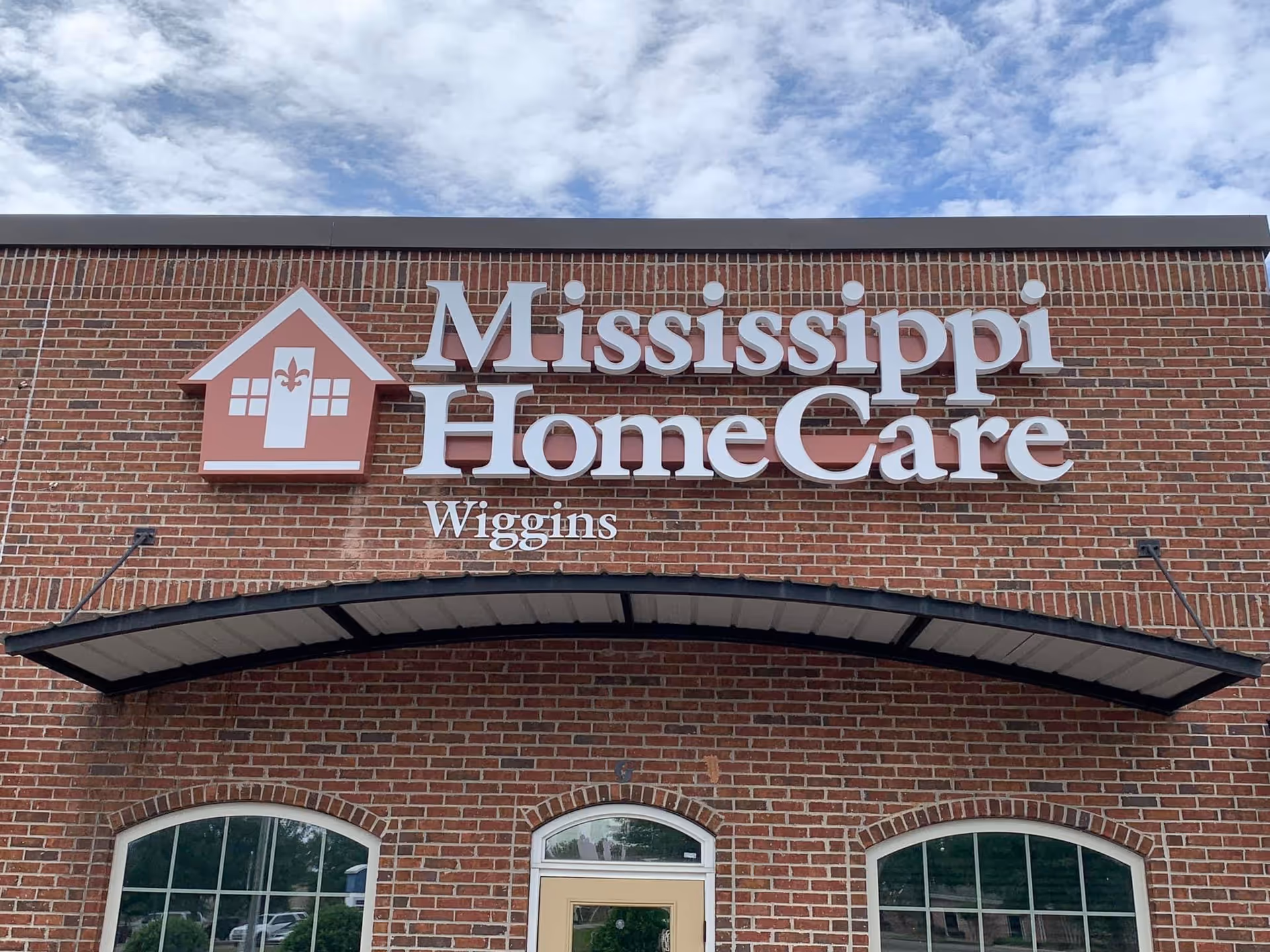 Exterior brick building facade with Mississippi HomeCare sign above a doorway.
