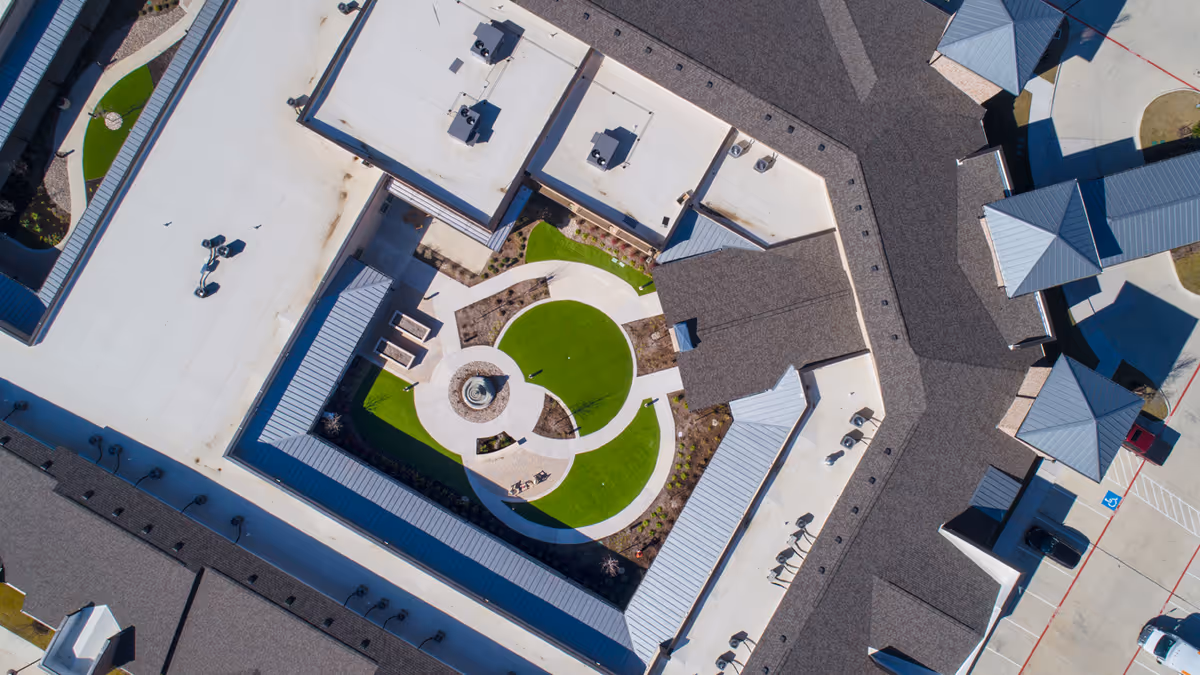 Aerial view of a senior living facility courtyard with circular green lawn and pathways.