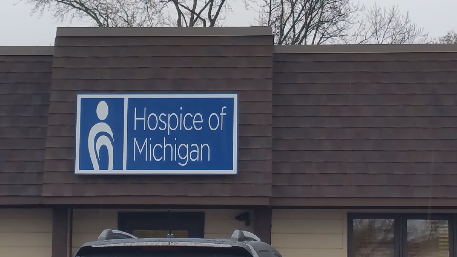 Exterior view of a Hospice of Michigan building with a blue sign.