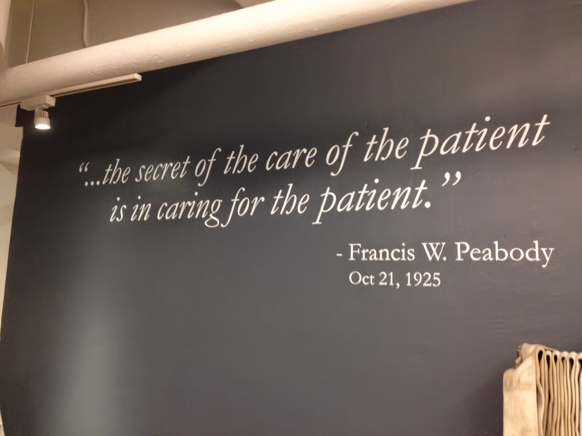 Interior wall features a large patient-care quote with a stack of chairs visible nearby.