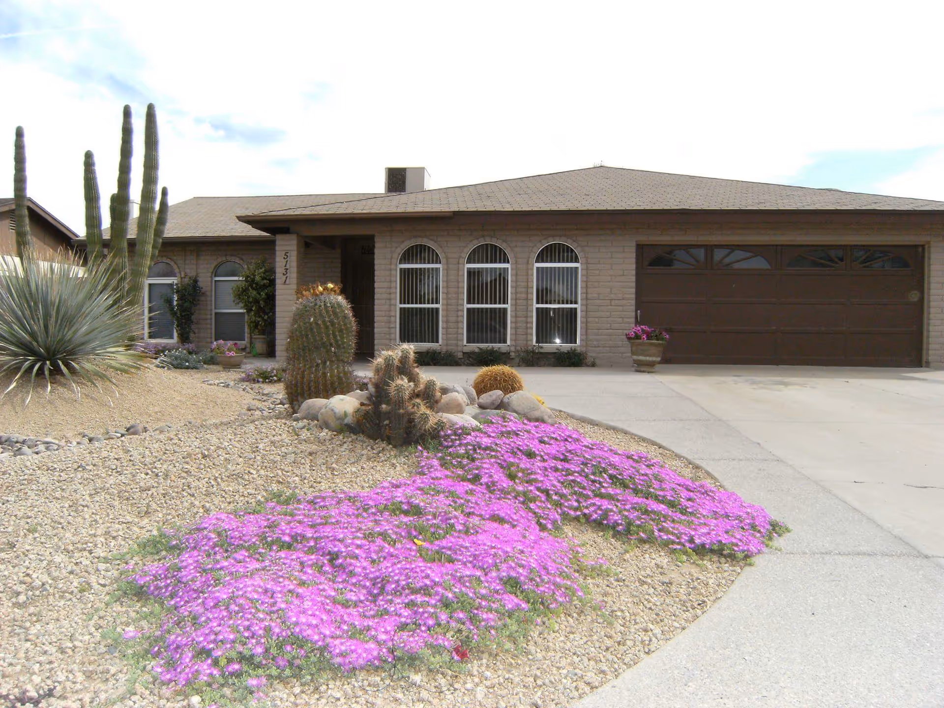 Front view of Valley Oasis Adult Care Home with desert landscaping and a garage.