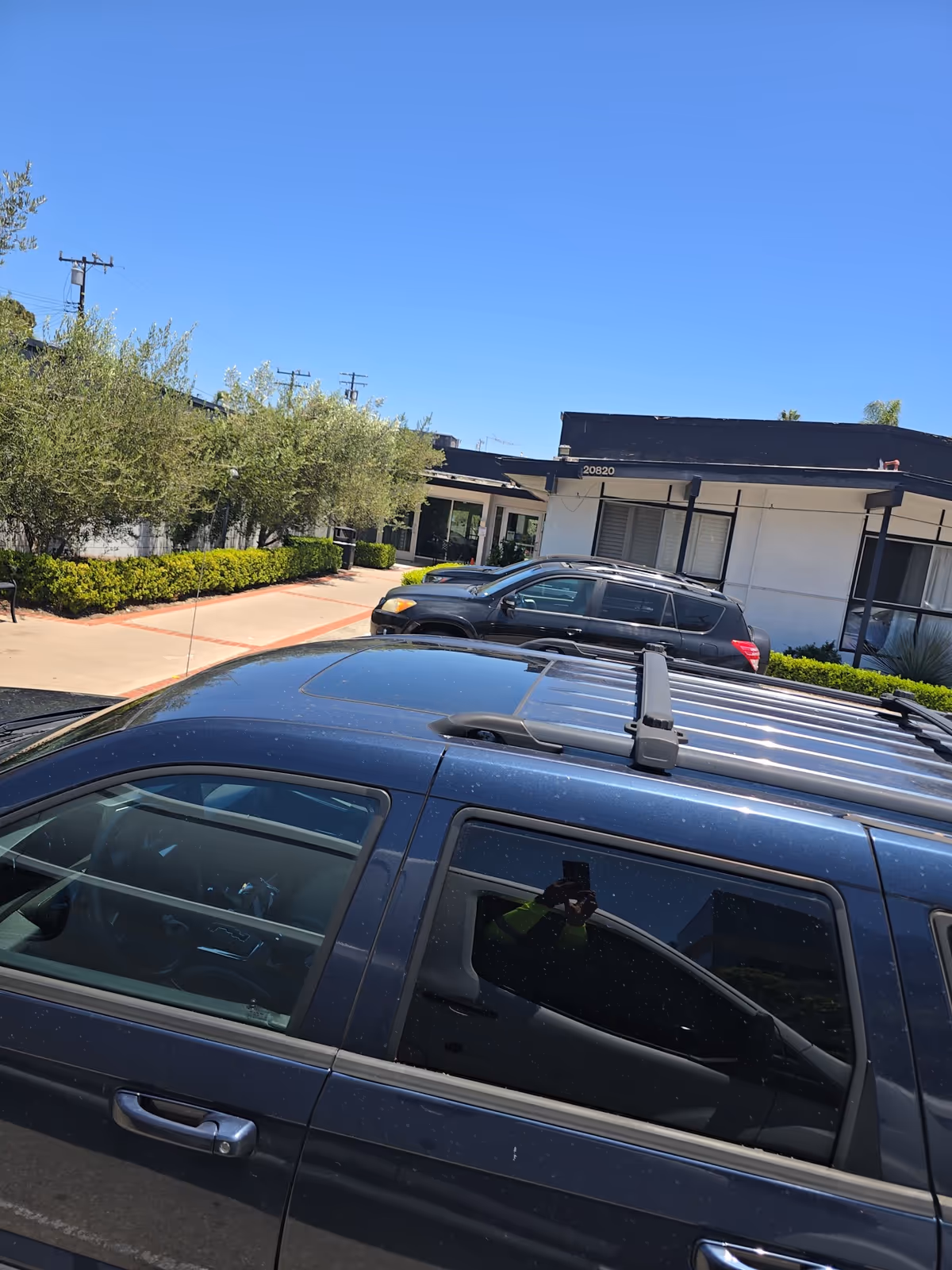 View of The Earlwood senior living facility exterior with parked cars and clear blue sky.