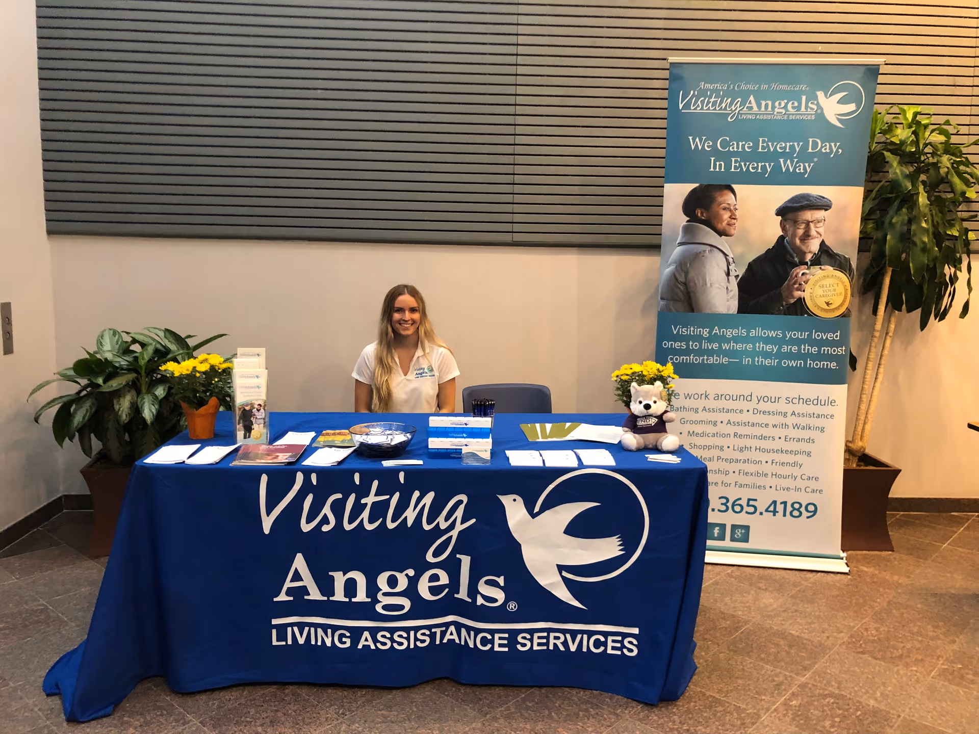 Reception area at Visiting Angels Senior Home Care Farmington Hills with staff at a promotional table.