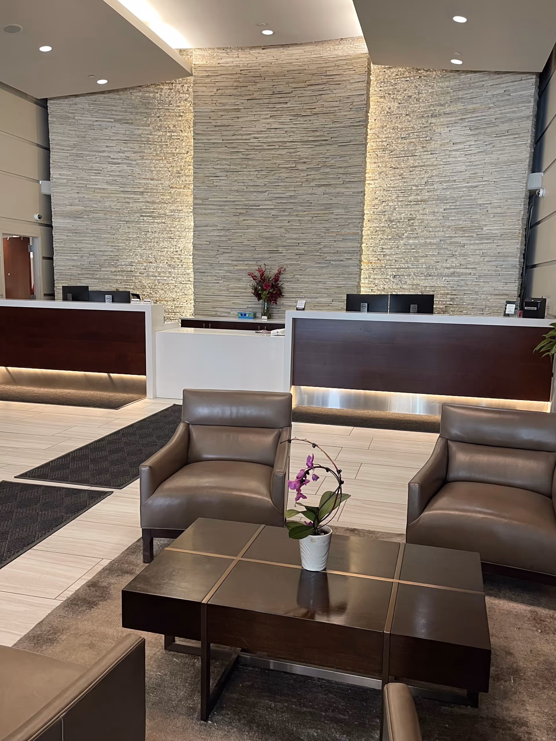 Allevia Home Care lobby with stone accent wall, reception desks, and leather seating.