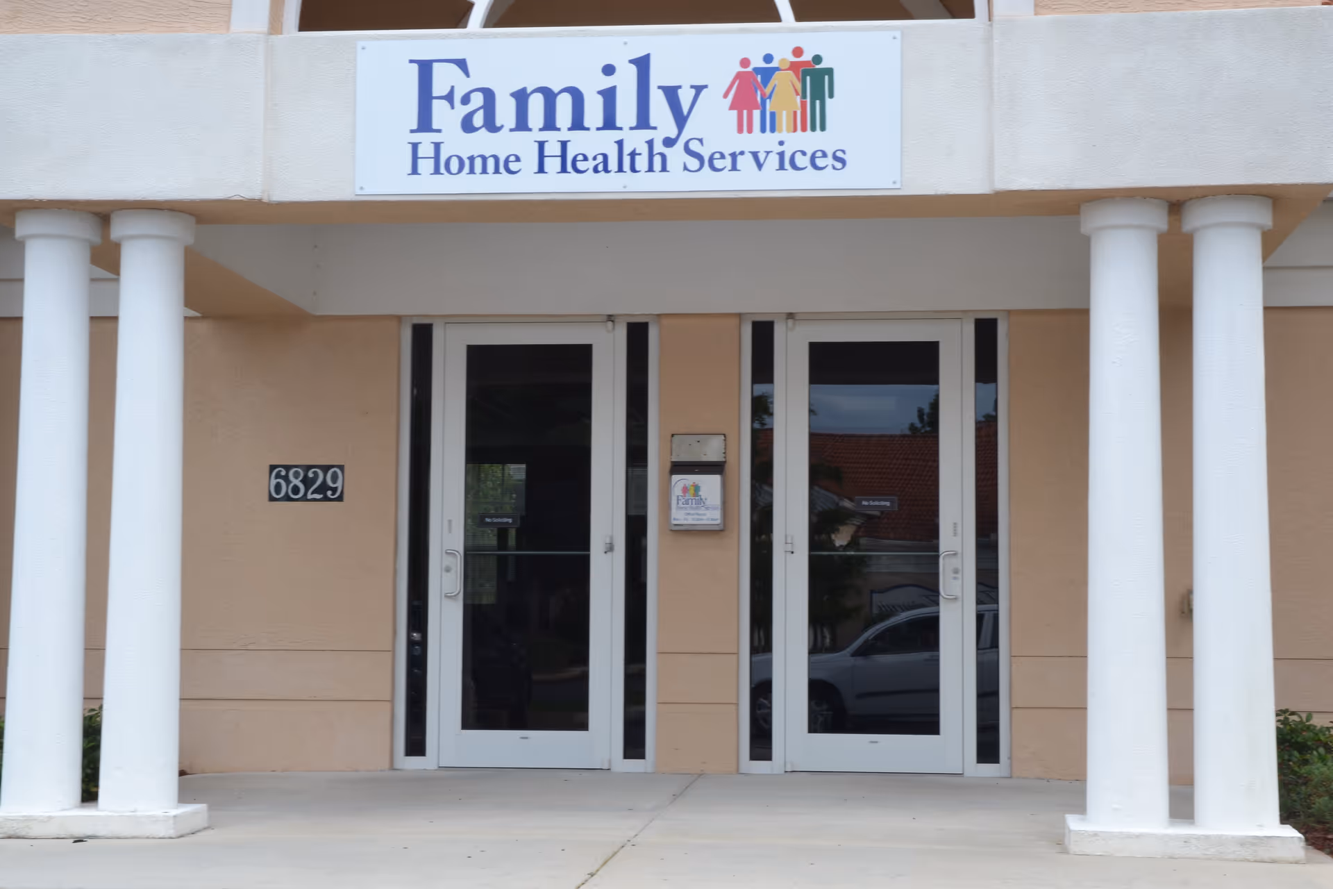 Front entrance of a Family Home Health Services building with glass doors and columns.