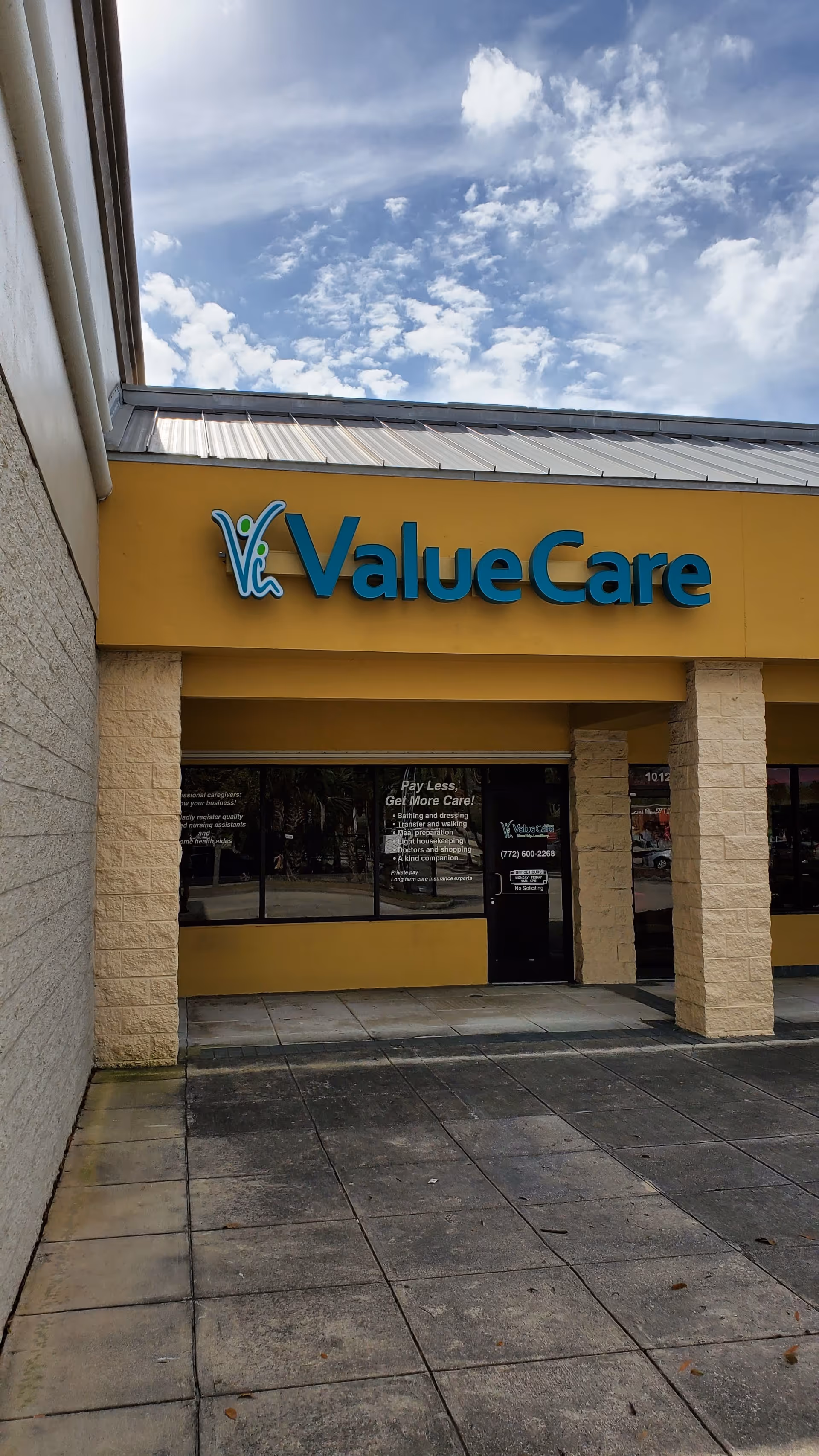 ValueCare storefront with yellow facade and glass doors under cloudy sky.